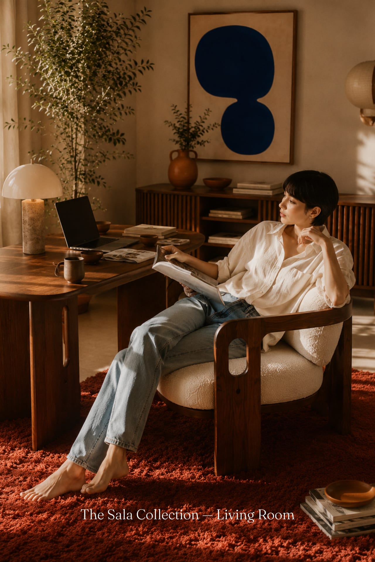 A woman reads in the Sala walnut and bouclé armchair.