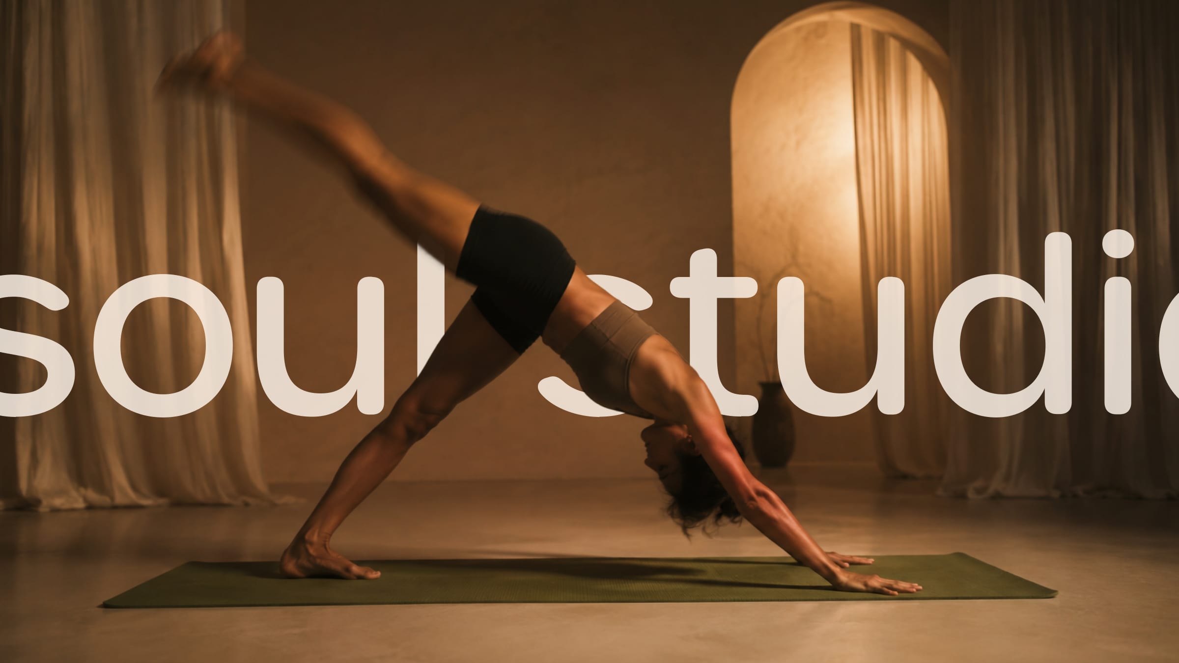 A woman in downward dog across the soul studio wordmark.